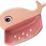 Pink whale-shaped pouch with a small white ball inside on a light pink background