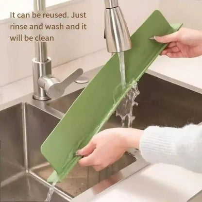 Person washing a green cutting board under running water in a kitchen sink.