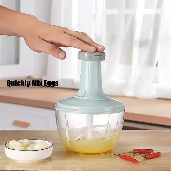 Hand using a kitchen mixer on a wooden surface with ingredients.
