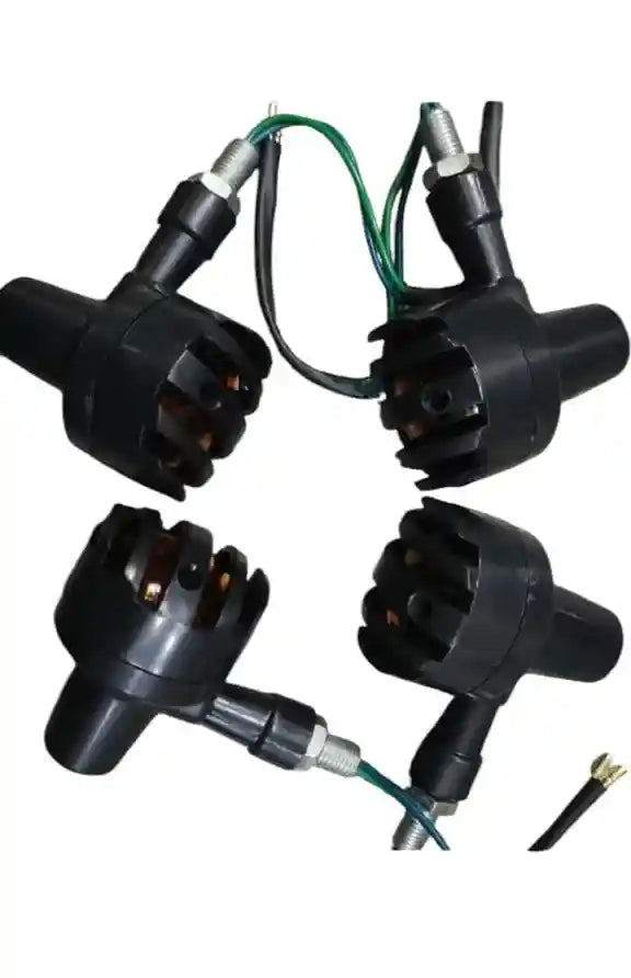 Four black ignition coils with wiring on a white background