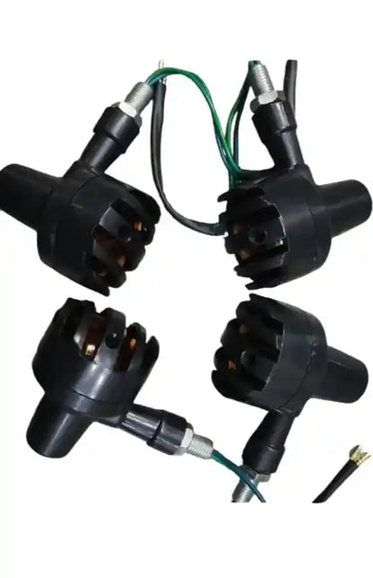Four black ignition coils with wiring on a white background
