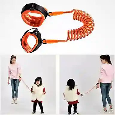 Orange leash with black connectors on a white background, with two people using it to walk a child.