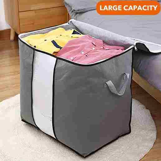 Gray storage bag with clothes on a bed, labeled 'Large Capacity'.