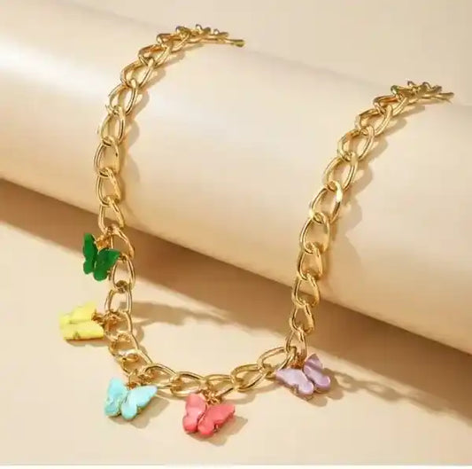 Gold chain bracelet with colorful butterfly charms on a beige background