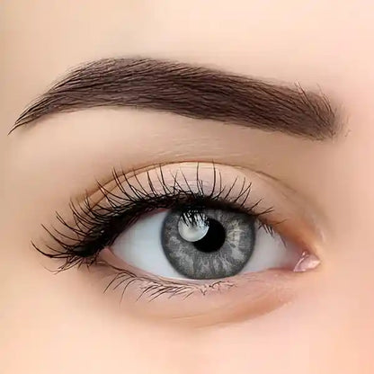 Close-up of a blue eye with detailed eyelashes and eyebrow on a beige background