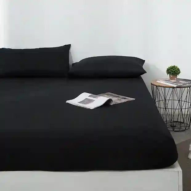 Black bed sheets on a bed with a minimal background