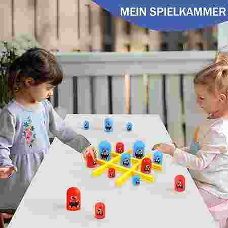 Two children playing with colorful toys at a table outdoors.