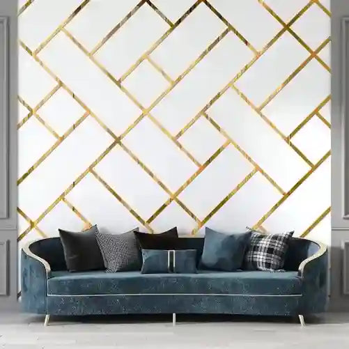Blue sofa with decorative pillows against a gold geometric patterned wall.