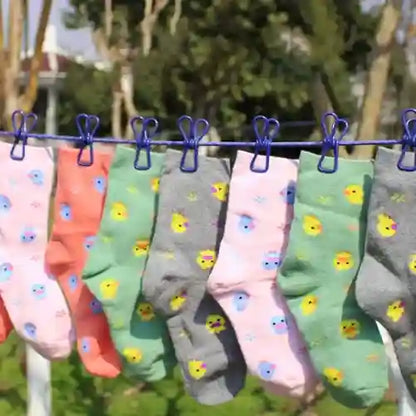 Colorful socks with duck patterns hanging on a clothesline against a natural background.