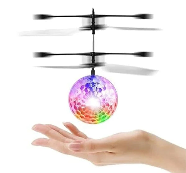 Colorful disco ball with spinning propellers held in a hand against a white background