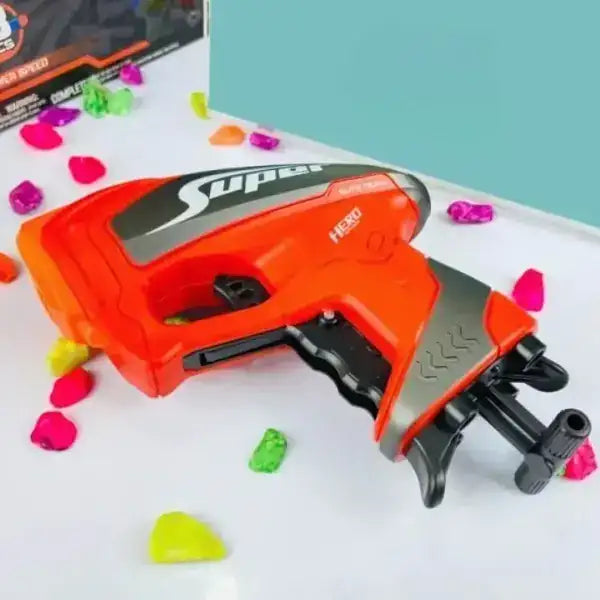 Toy gun labeled 'Super Hero' with colorful heart-shaped darts on a white surface.