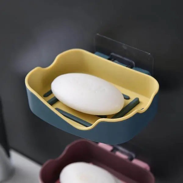 Yellow and blue soap holder with a bar of soap on a dark background