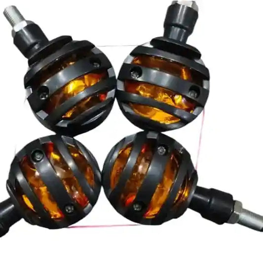 Four motorcycle turn signals with amber lenses and black metal casings on a white background.