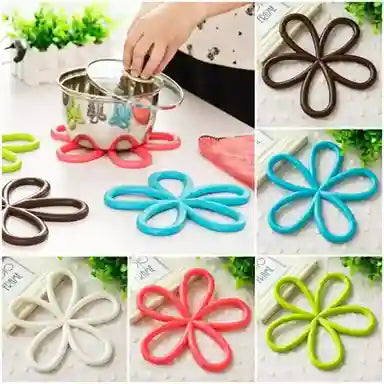 Colorful flower-shaped coasters with a hand placing a cup on one of them.