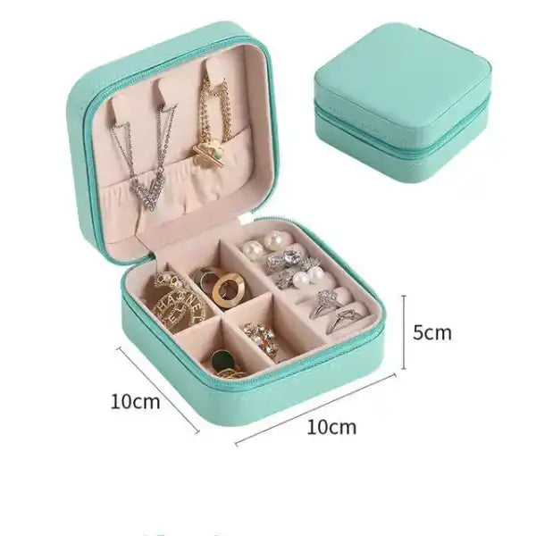 Teal jewelry box with jewelry inside, showing dimensions on a white background