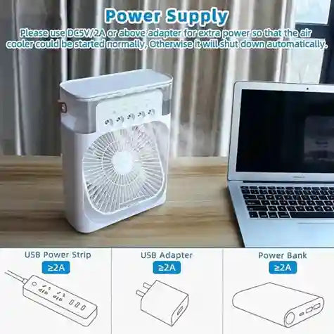 Small air cooler on a desk next to a laptop with power supply instructions.