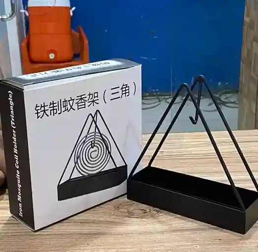 Black metal triangle-shaped holder next to its packaging box on a wooden surface.