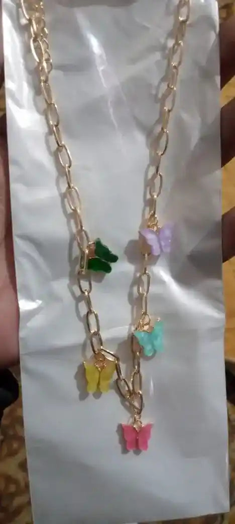Gold chain necklace with colorful butterfly charms on a white card.