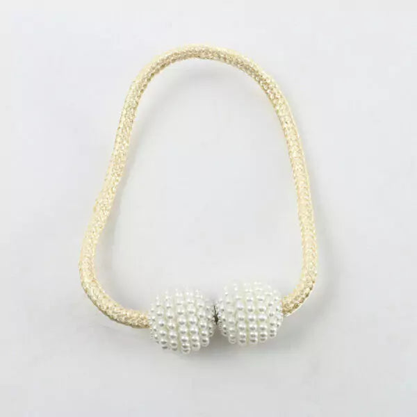 Necklace with gold chain and pearl-like beads on a light gray background