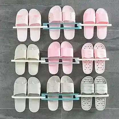 Shoe rack holding multiple pairs of pink and white slides on a gray wall.