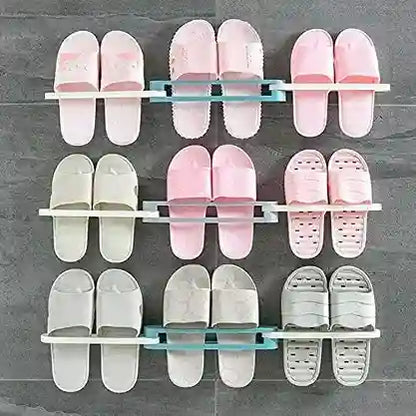Shoe rack holding multiple pairs of pink and white slides on a gray wall.