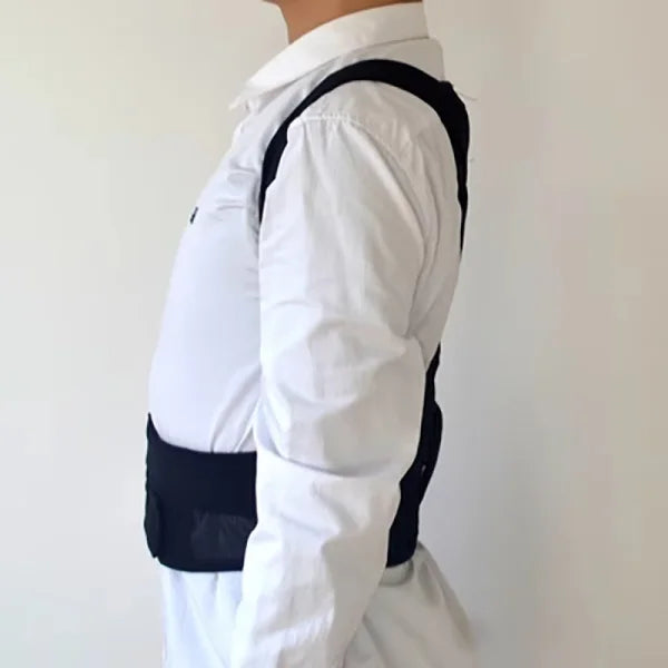 Person wearing a white shirt with black arm brace on a plain background
