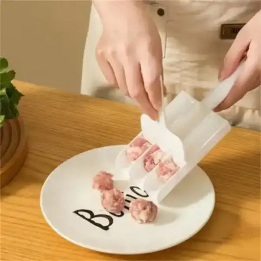 Person using a meatball maker on a plate with 'Bella' written on it.
