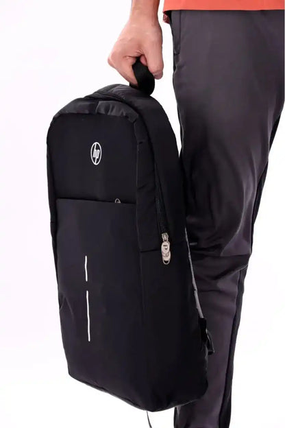Person holding a black backpack with a visible brand logo on a white background