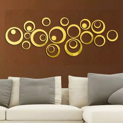 Gold circular wall art on a brown wall above a white sofa with gray cushions.