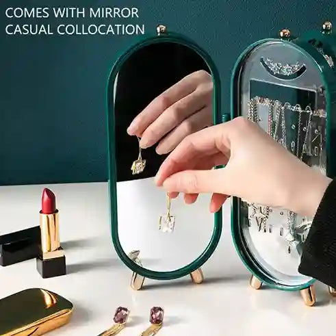 Person trying on earrings with a mirror and makeup items on a table.