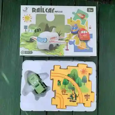 Children's toy set with a box labeled 'Railcar Puzzle' on a green surface.