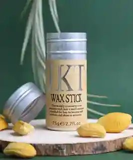 KT Wax Stick container on a wooden surface with leaves in the background