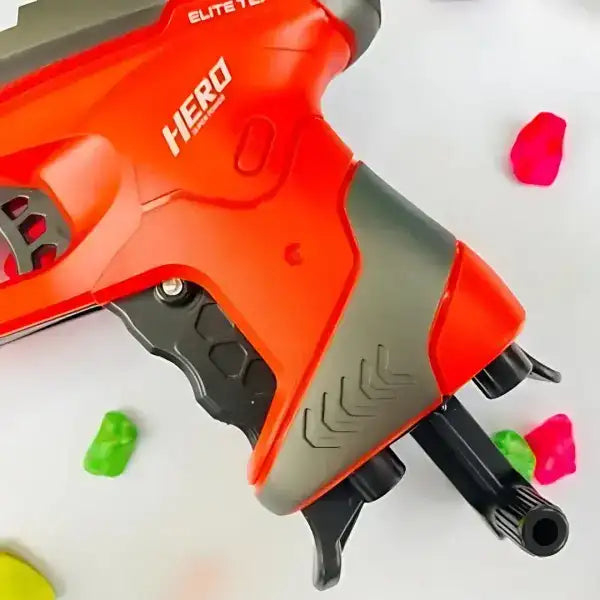 Red and gray toy gun labeled 'Hero' with colorful darts on a white background