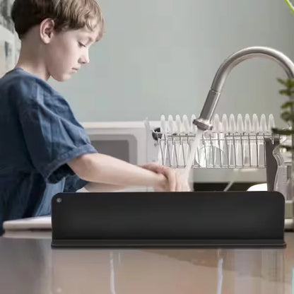 Child using a tablet at a kitchen sink with a dish rack in the background