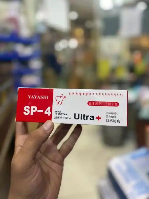Yayashi SP-4 Ultra toothpaste box held by a hand in a blurred store setting