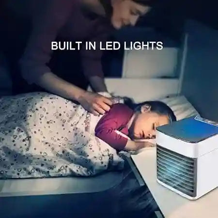 Person using a portable air conditioner with built-in LED lights in a dark room.