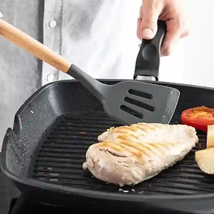 Person cooking chicken breast in a grill pan with a spatula