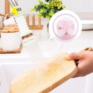 Person using a spray nozzle to clean a wooden cutting board with a kitchen setting in the background.