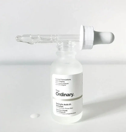 Skincare serum bottle with dropper labeled 'The Ordinary' on a light background