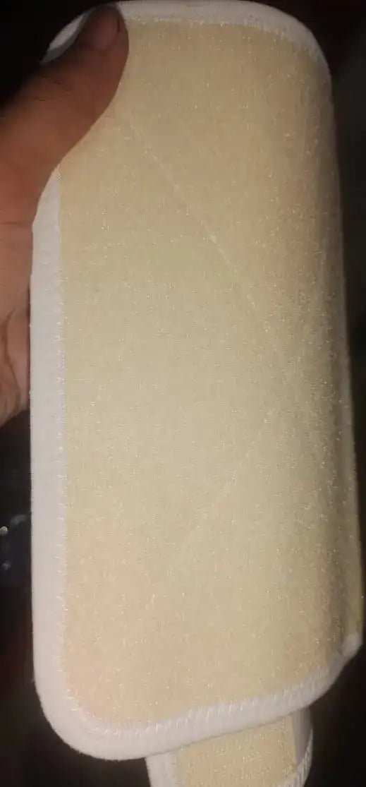 Beige rectangular object held by a hand with a dark background