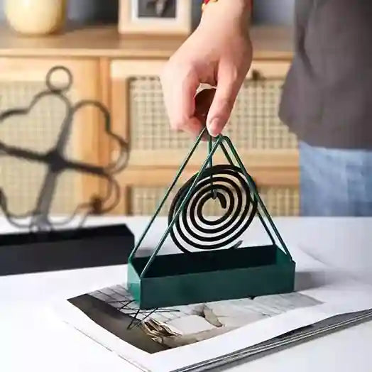 Person holding a green triangular object with concentric circles on a table.