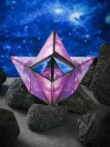 Geometric purple and pink light fixture on dark rocks with a starry night sky background