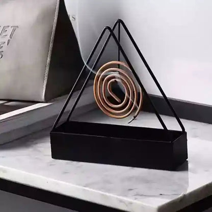 Triangular black metal holder with coiled rope on a marble surface