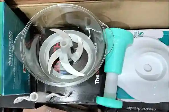 Silicone kitchen tool with a white plastic component on a cardboard box background