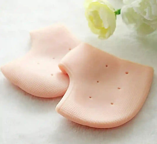 Two silicone breast forms on a white surface with flowers in the background