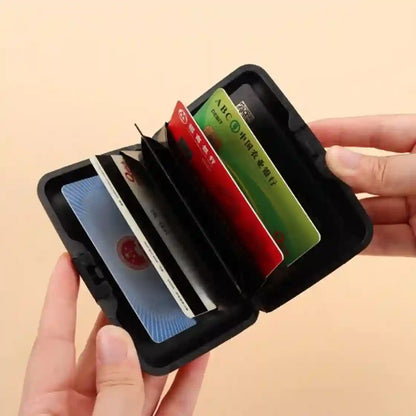 Black cardholder with multiple cards inside, held by a hand on a beige background