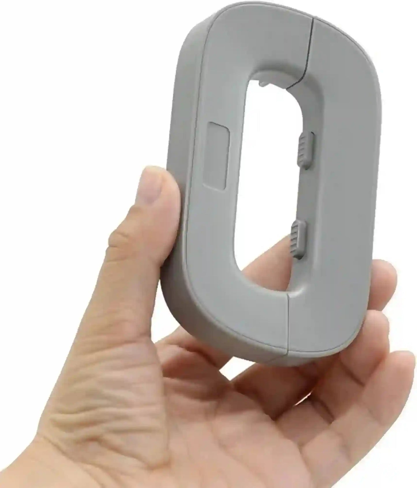Hand holding a small gray electronic device on a white background