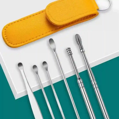 A set of stainless steel ear cleaning tools arranged on a white surface with a teal background, alongside a bright yellow felt carrying pouch and key ring.