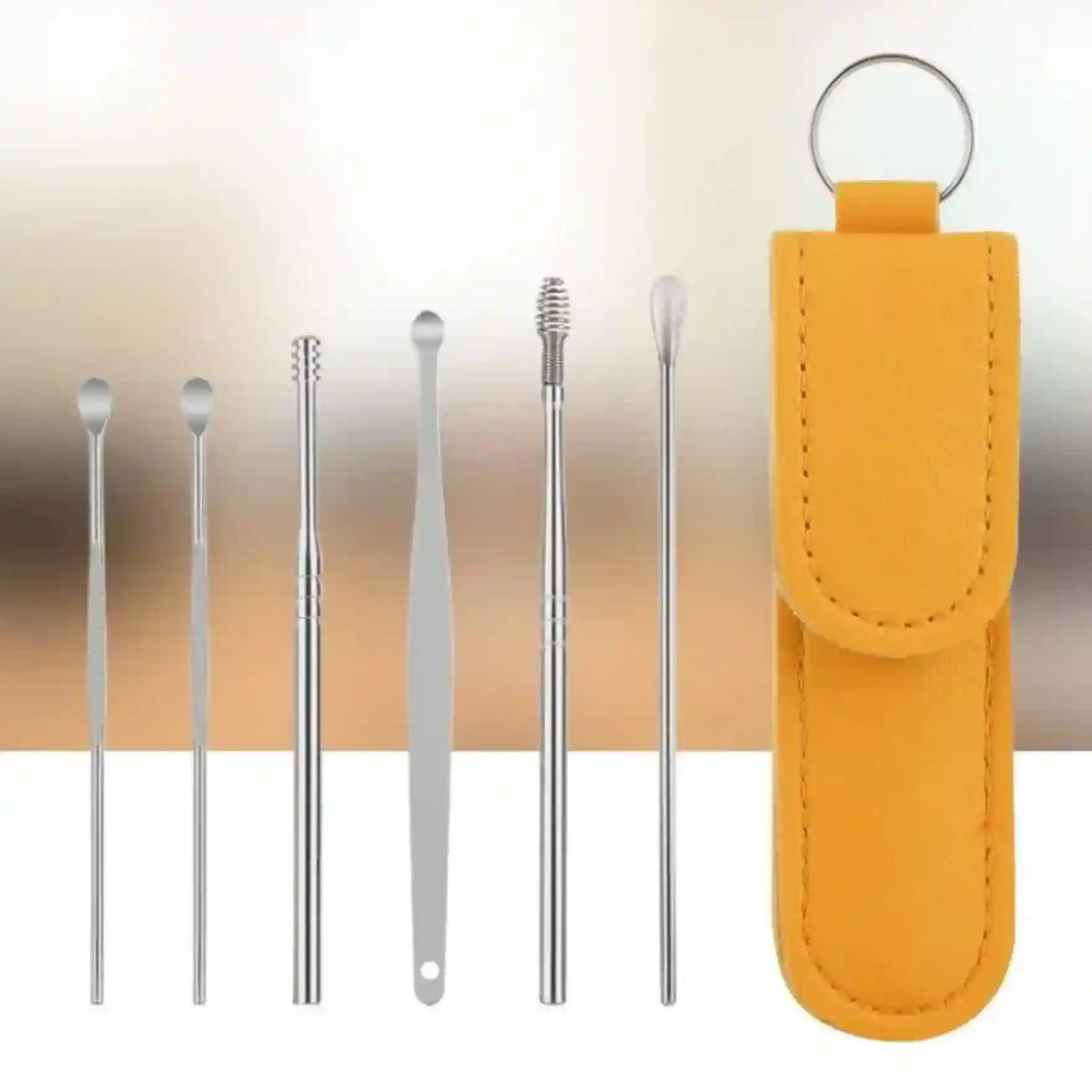 Set of metal ear cleaning tools with a yellow case on a gradient background