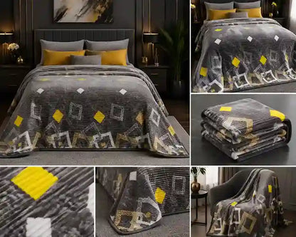 A dark gray and black geometric patterned throw blanket with yellow and white accents, shown in a bedroom setting on a bed, folded, and draped over an armchair.